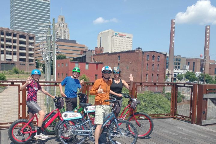 a group of people riding on the back of a bicycle