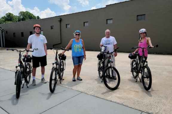 a group of people riding on the back of a bicycle
