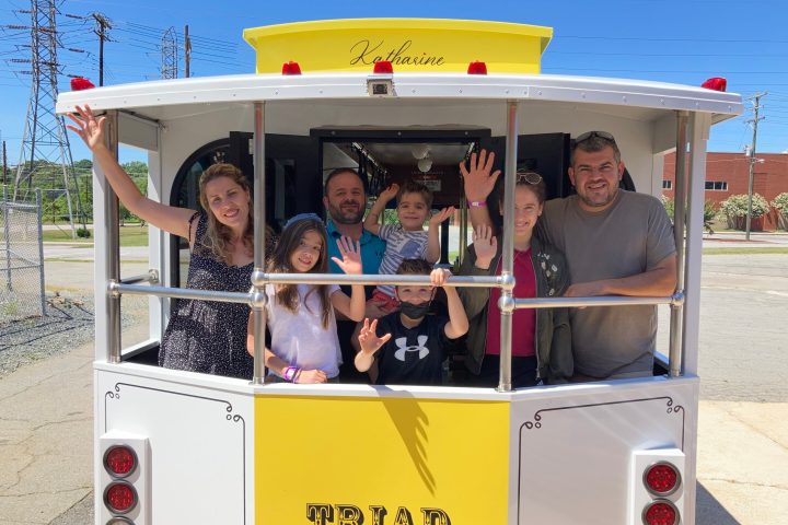 a group of people standing in front of a bus