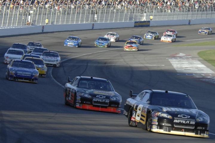 NASCAR track with NASCAR cars driving around loop