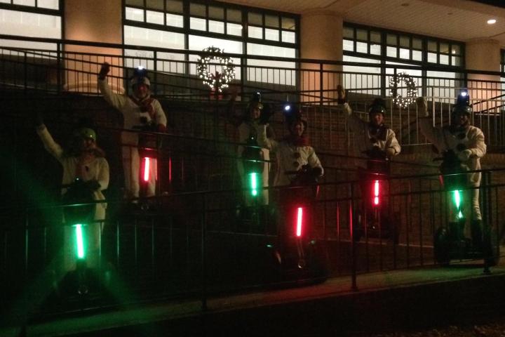 People on segways at night with glow sticks