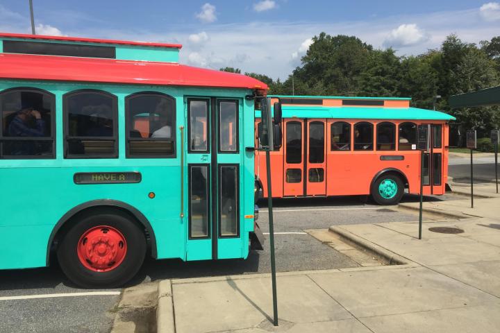 Two trolleys, one teal and the other is orange