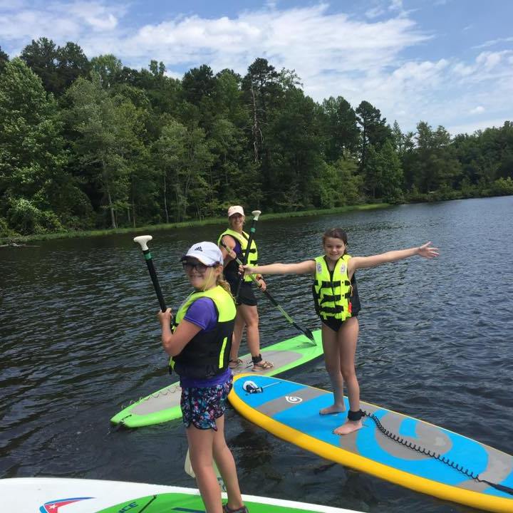 A mom and her daughters on stand up paddleboards
