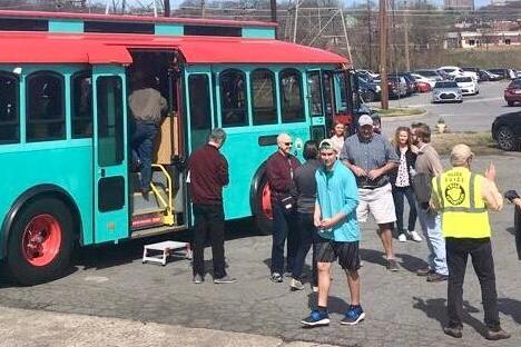 a group of people standing around a bus