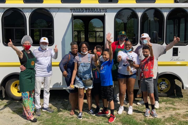 a group of people standing in front of a bus