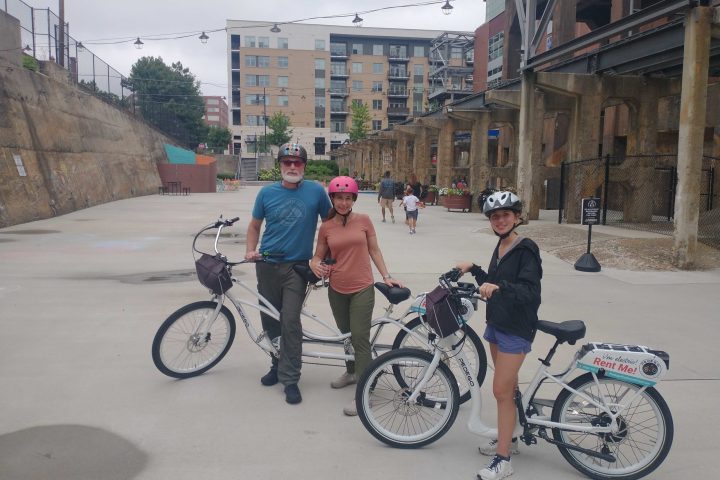 a group of people riding on the back of a bicycle