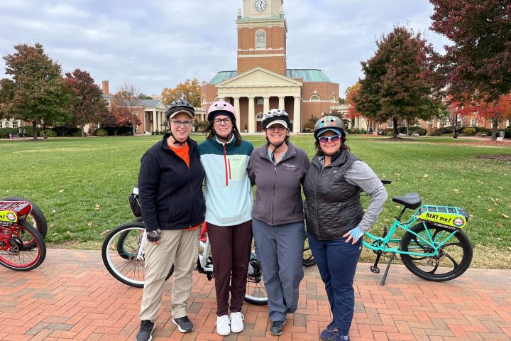a group of people standing next to a bicycle