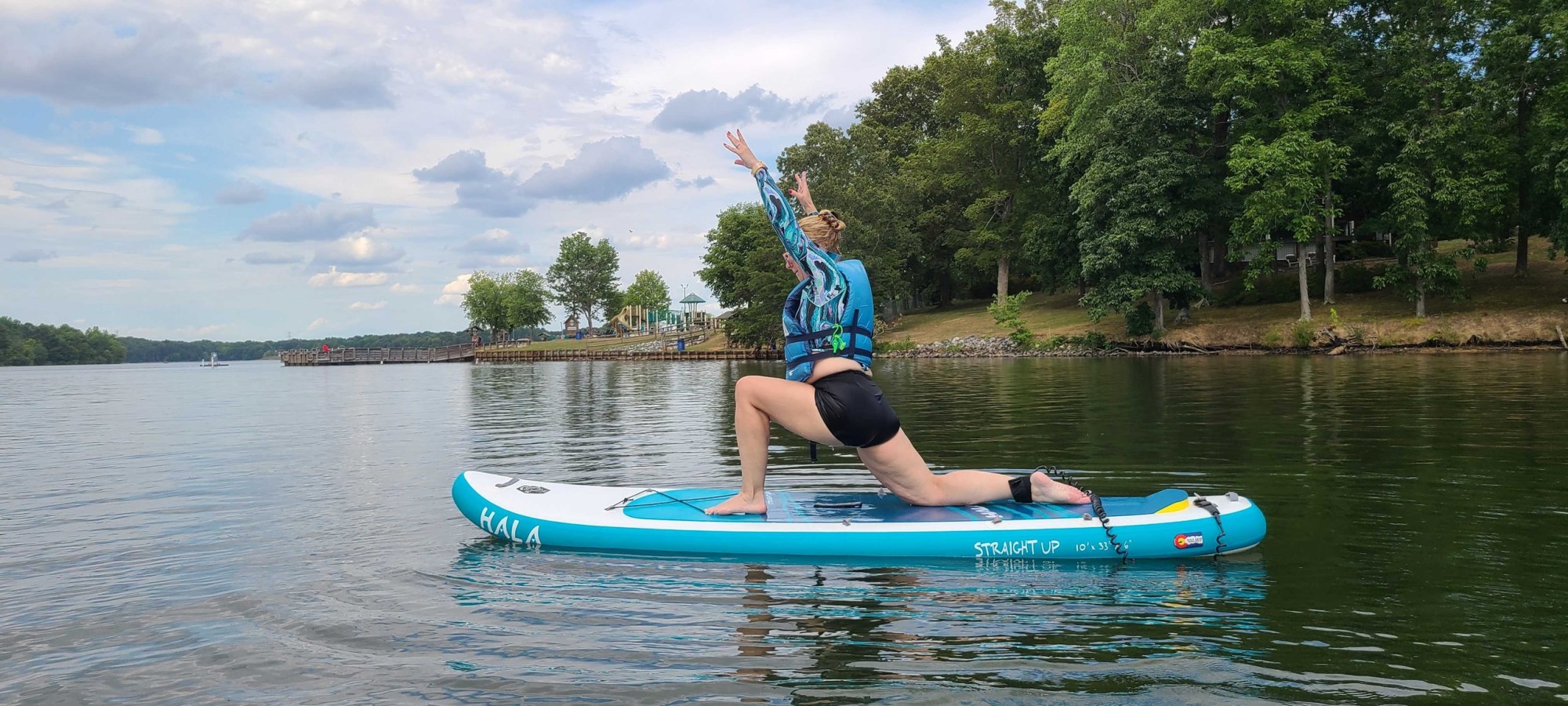 SUP Yoga with Terrie Thoma @ Oak Hollow Lake Image 1 a person riding on the back of a boat in a body of water