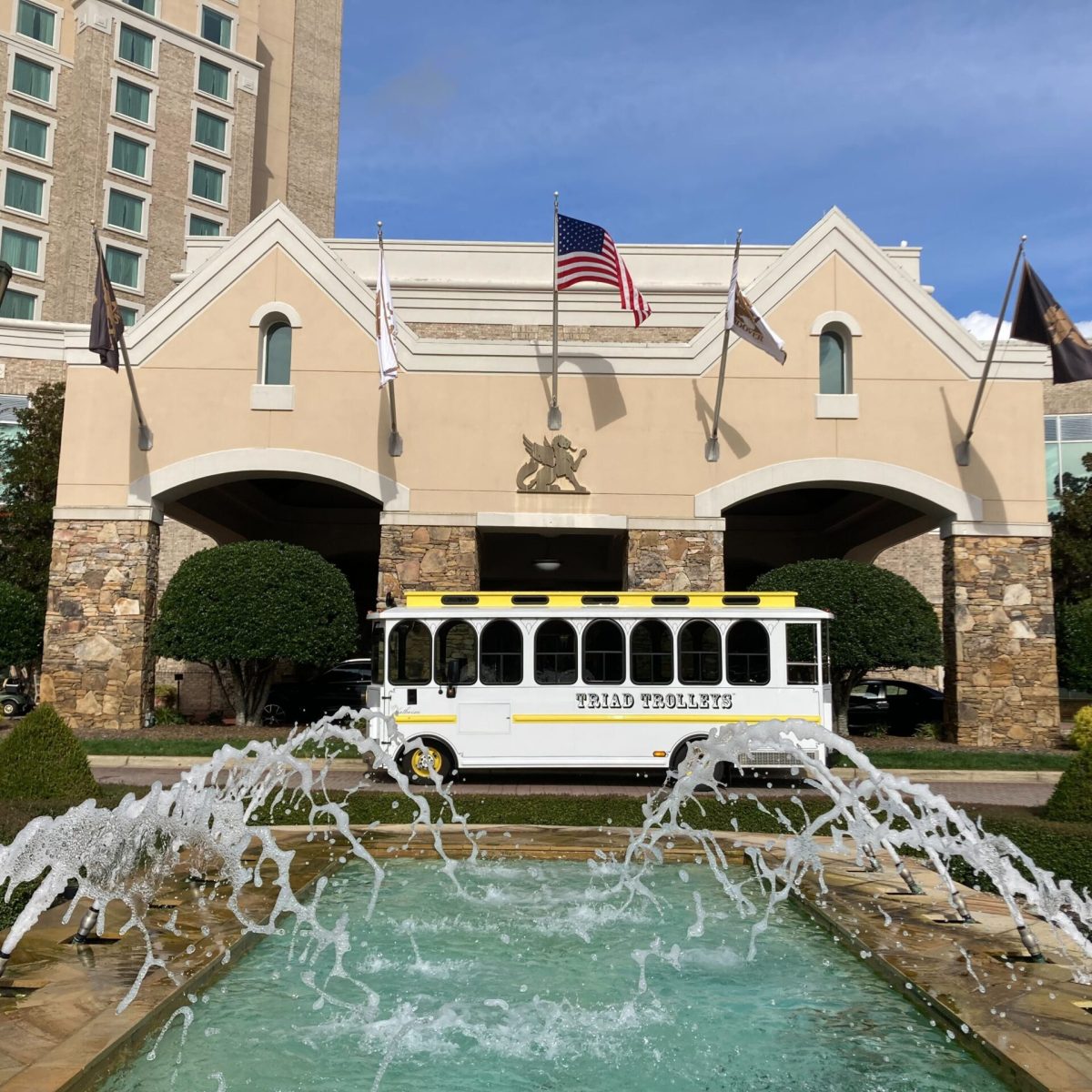 a large brick building with grass in front of a river