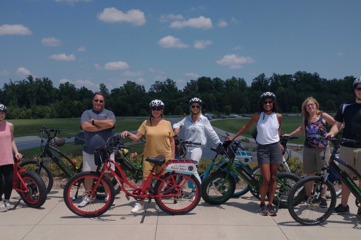 a group of people riding on the back of a bicycle