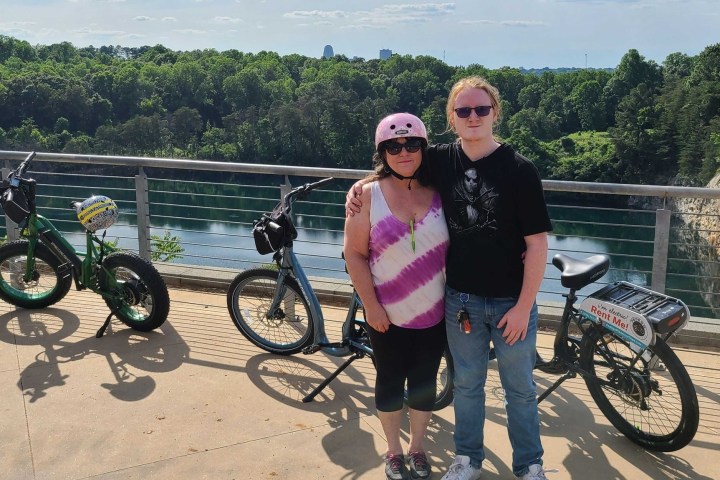 a woman riding a bike down a dirt road