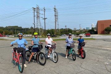a group of people riding on the back of a bicycle