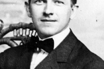 Vintage portrait of a young man with slicked-back hair and a bow tie.